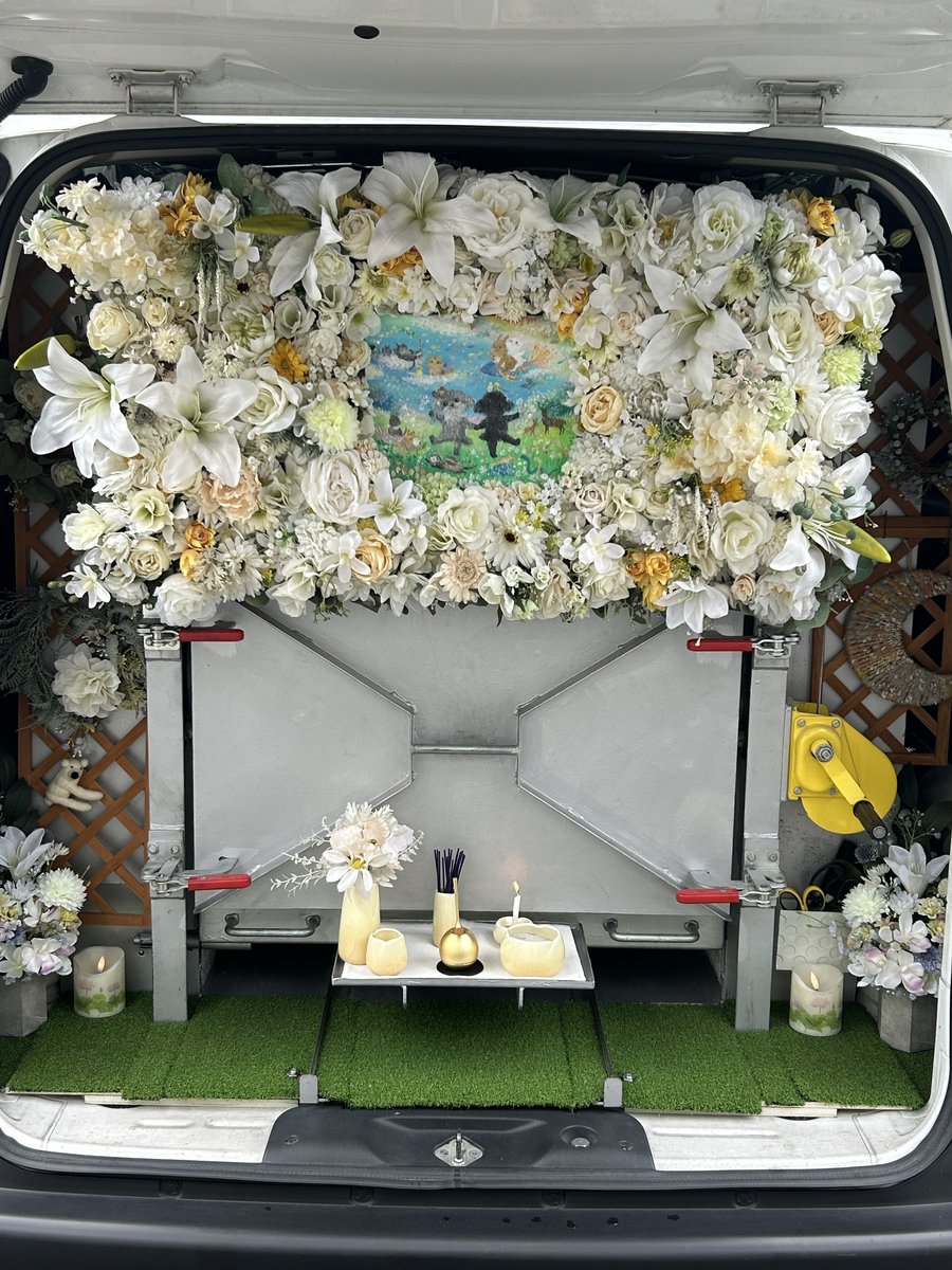 花で飾られた火葬車後部の祭壇と火葬装置